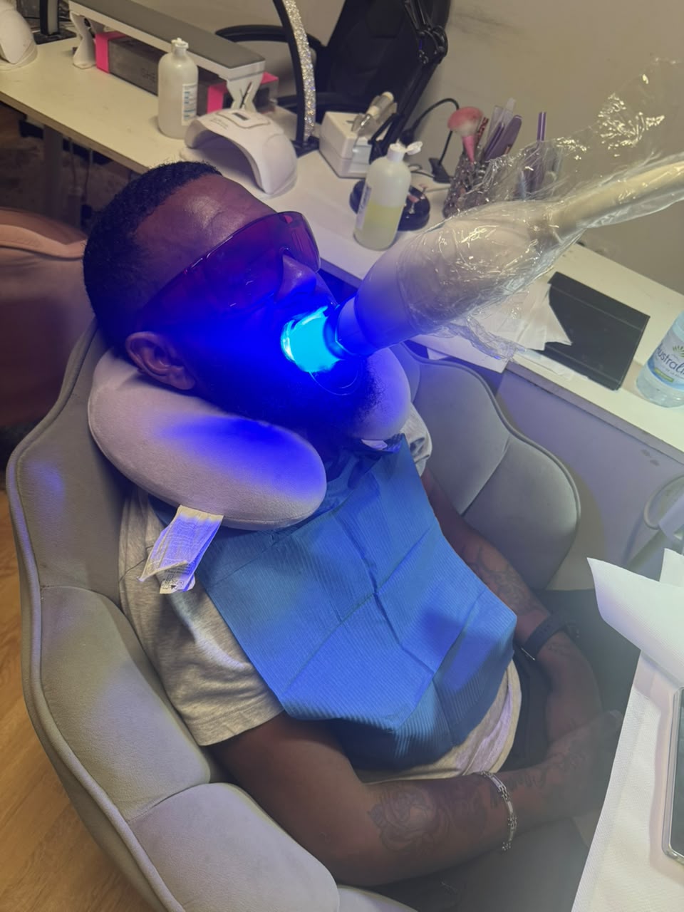 Un blanchiment en cours à l’institut, la lampe bleue allumée et les lunettes de protection